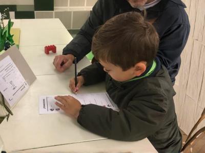 Dreng udfylder stemmeseddel til Børnevalget